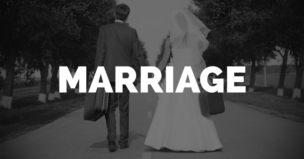 Divorce Lawyer Clearwater, FL recently married couple holding hands with luggage.
