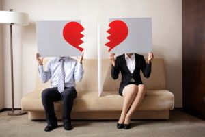man and woman with half of broken heart pages over their faces.