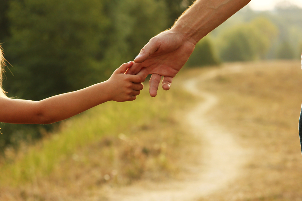 Tips For Parents Who Want Child Custody - parent holds the hand of a small child