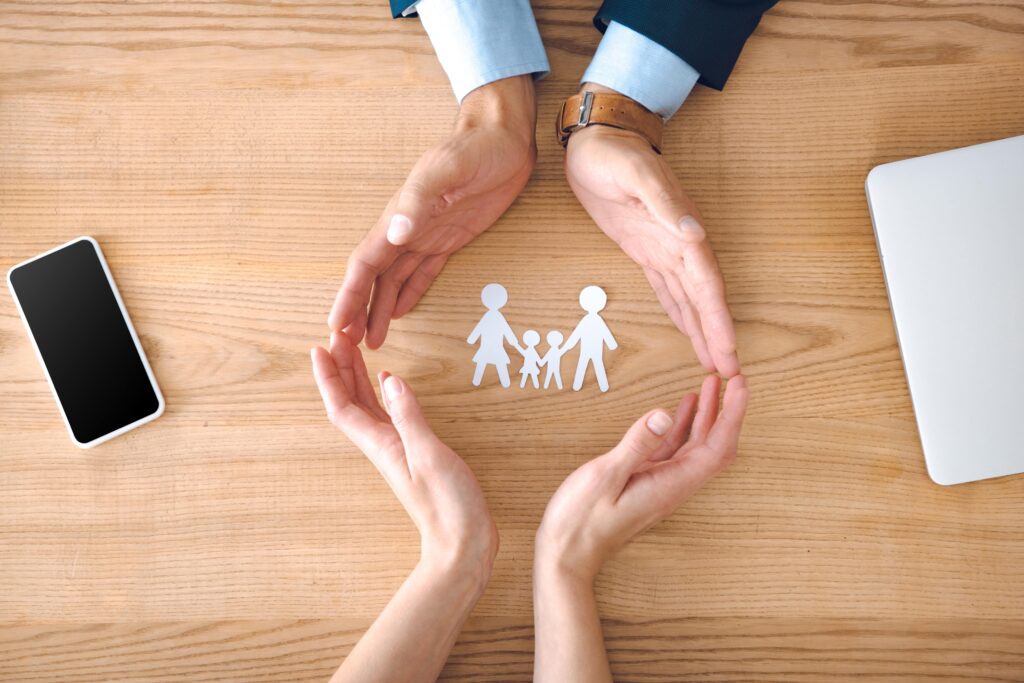 Adult hands circling paper cutout of family